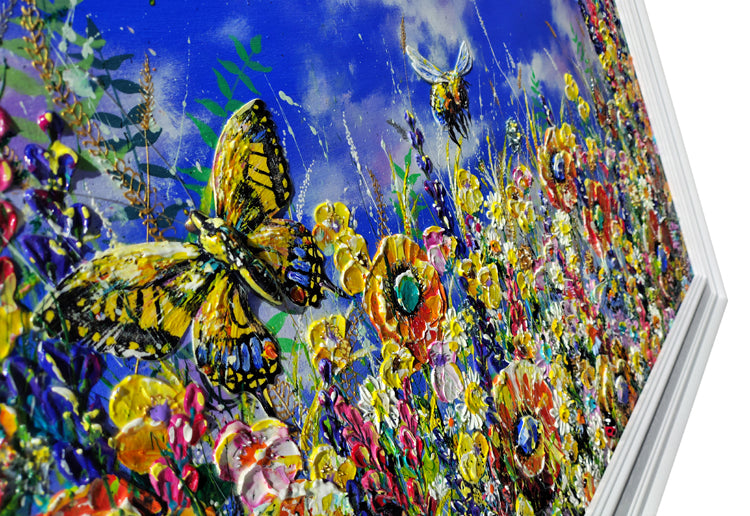 A close-up of a colorful floral and butterfly painting, showing a large yellow-and-black butterfly, smaller bees, and dense wildflowers under a vivid blue sky. The artwork is photographed at an angle with a white border visible around it.