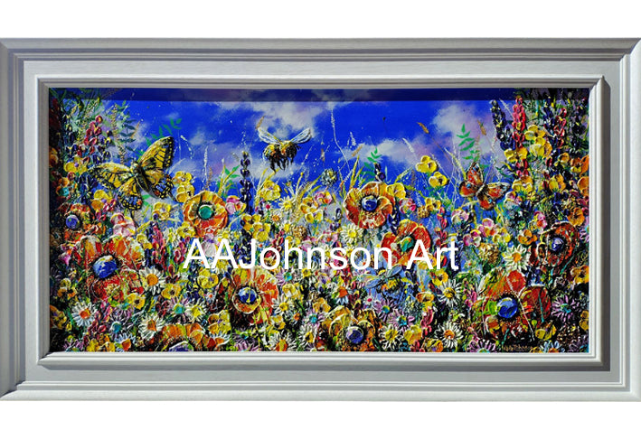 A framed colorful floral painting with a white frame, featuring a vibrant wildflower scene with a blue sky, butterflies, and a bee. 