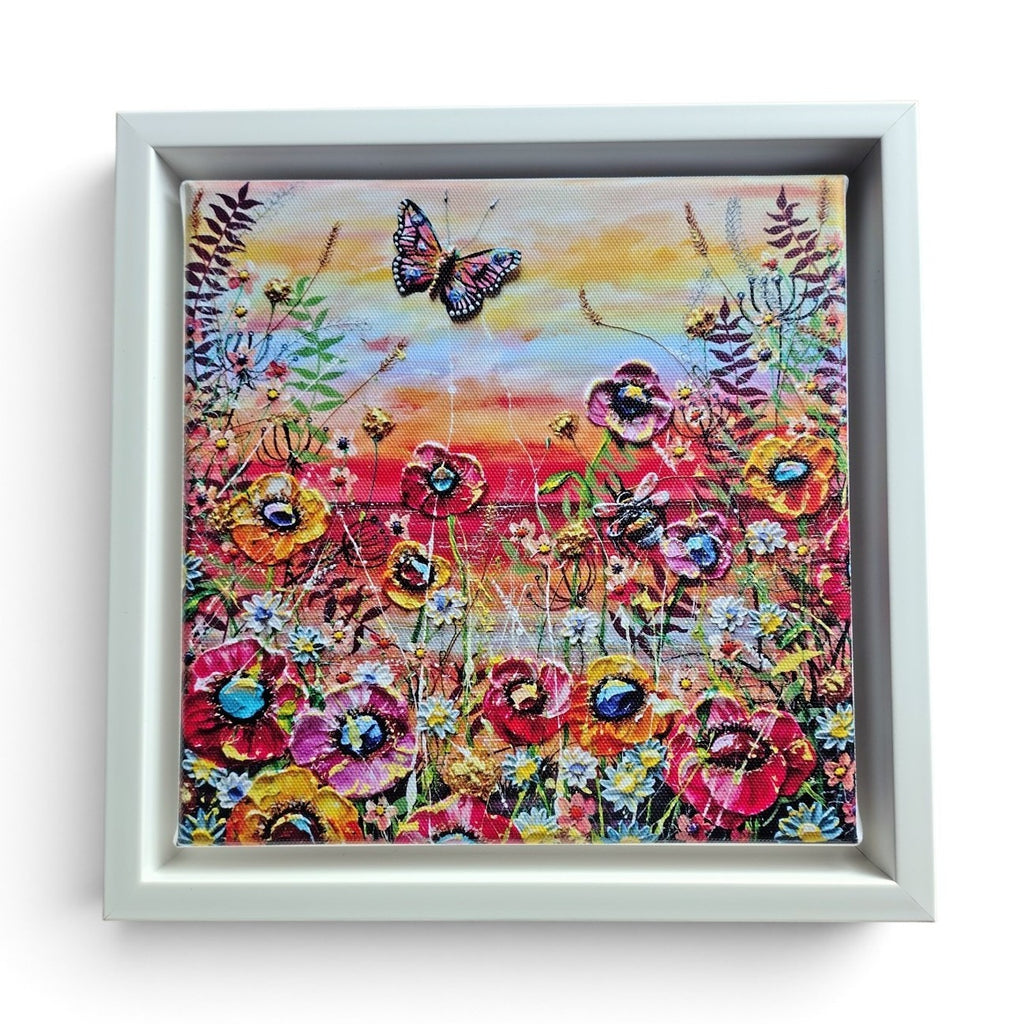 A square framed limited edition print on canvas depicting a vibrant field of flowers under a butterfly, with a white frame on a white background.