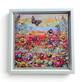 A square framed limited edition print on canvas depicting a vibrant field of flowers under a butterfly, with a white frame on a white background.